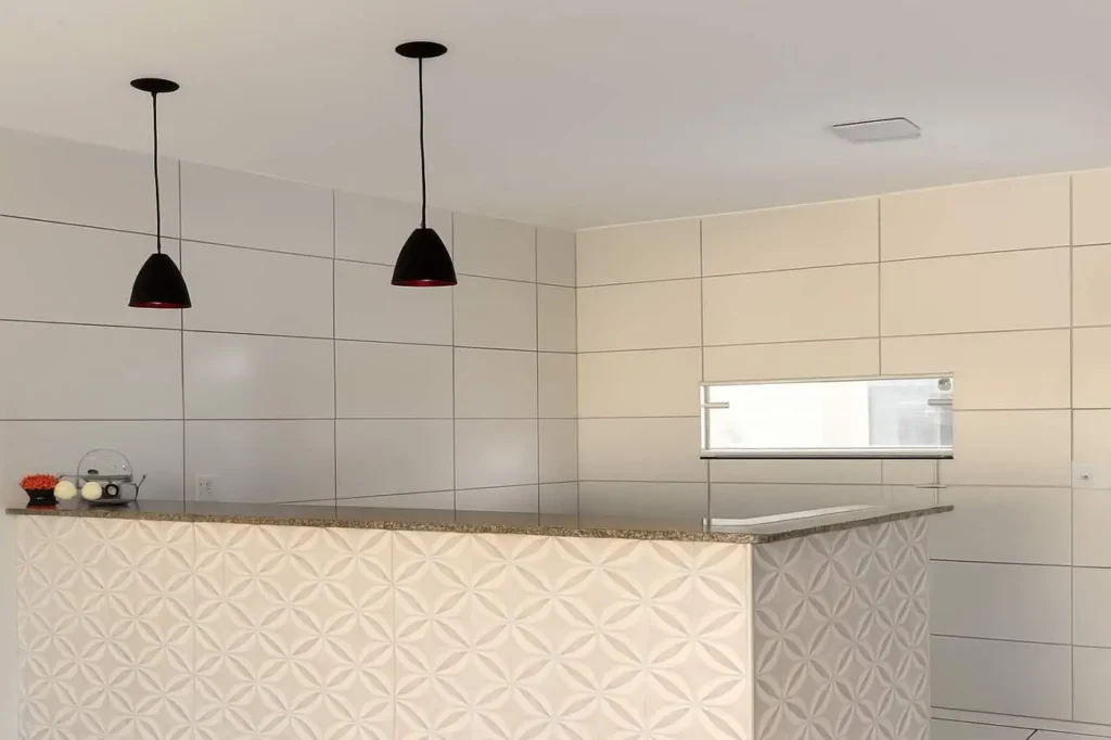 Cozinha com bancada e revestimento claro no Residencial Bom Lar